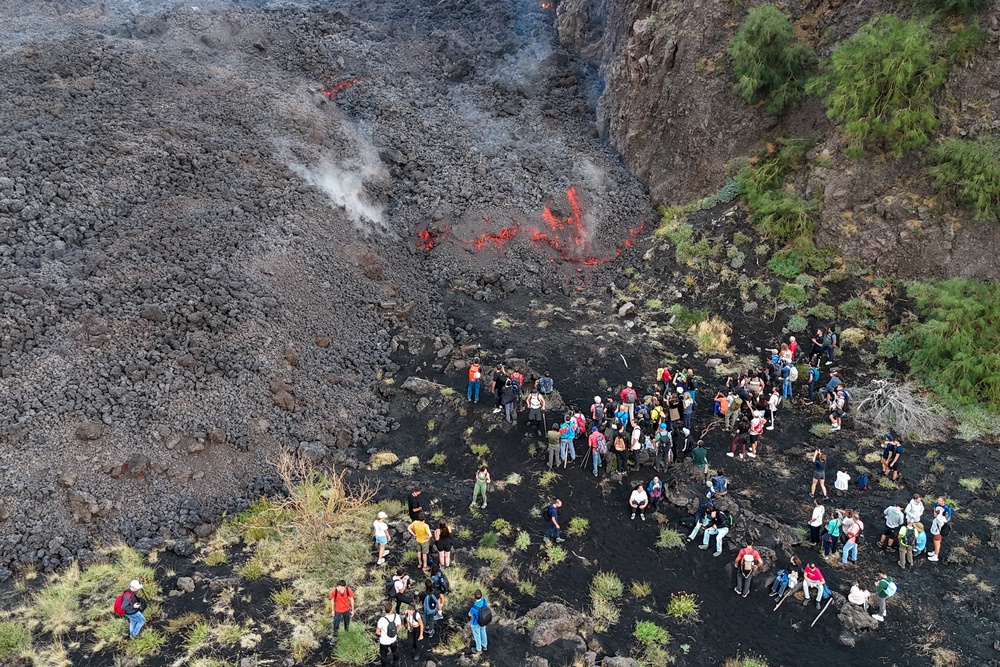 A drone view of people observing a volcanic eruption at Mount Etna (Reuters)