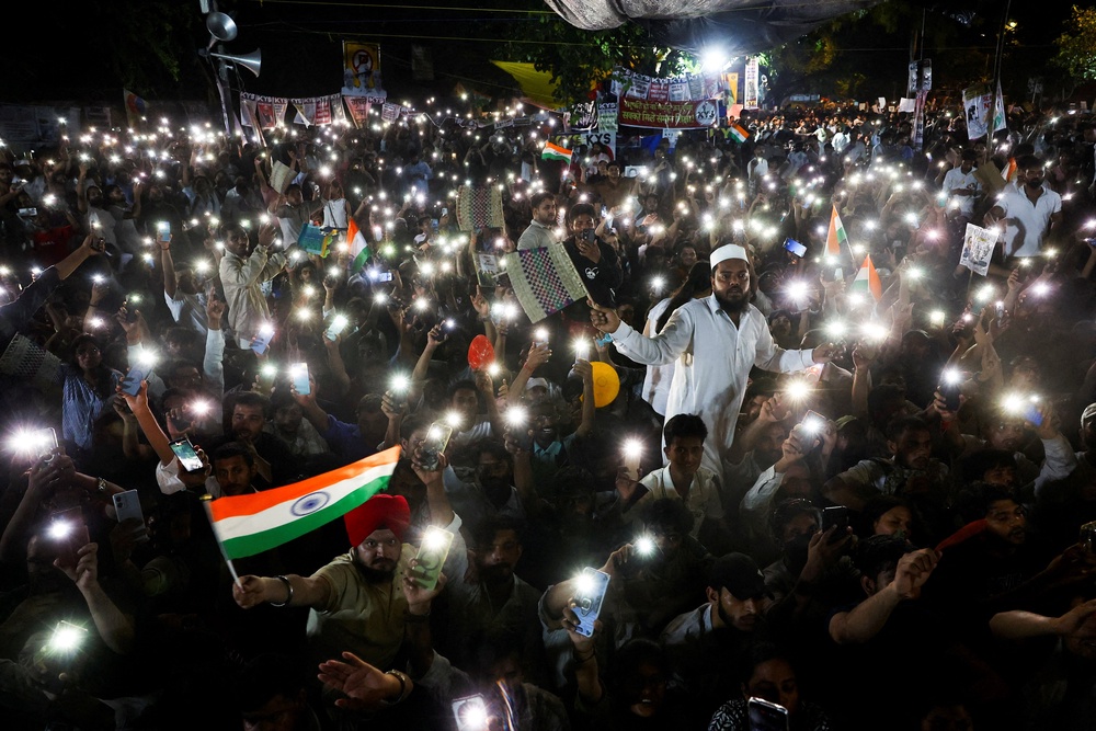 Supporters of the Cockroach Janta Party (CJP) chant slogans and wave their mobile phones with their flashlights on (Reuters)