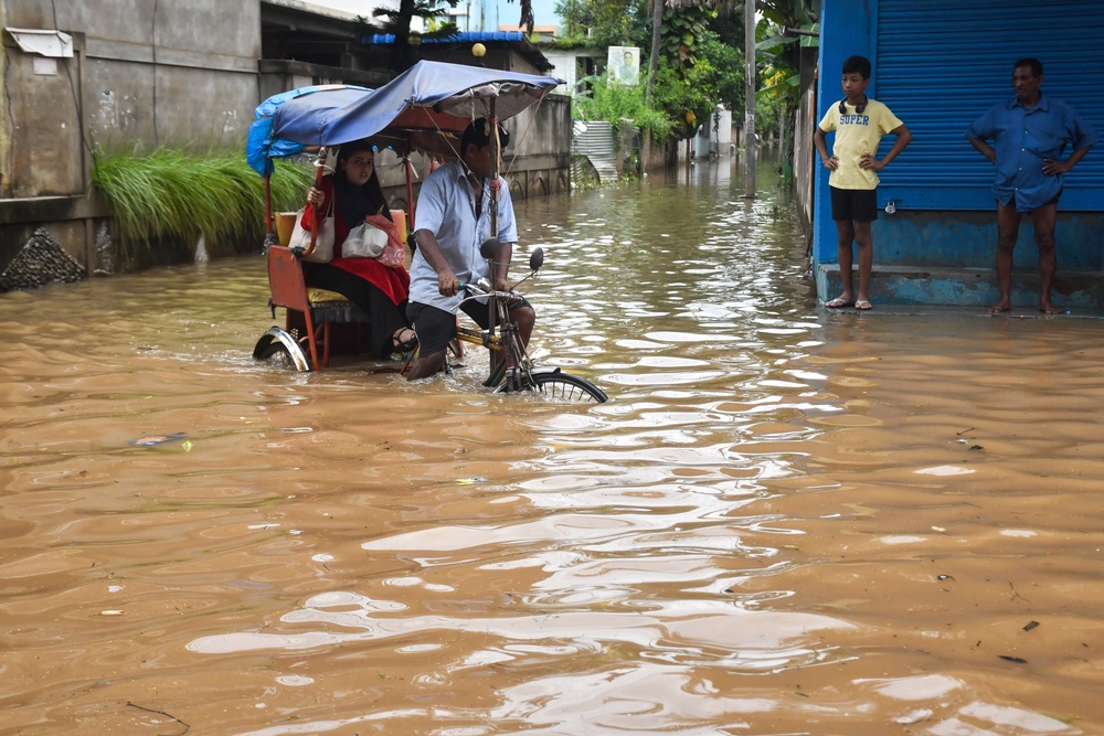 A resident commutes in a cycle rickshaw through a flooded street following heavy rainfall in Guwahati, Assam (AFP/Getty)