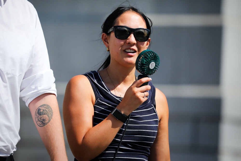 A person uses a fan to cool down in Trafalgar Square (Getty)