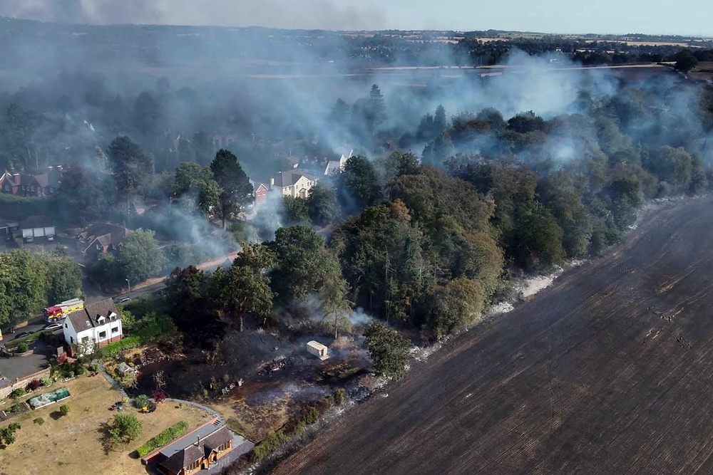 Drone video shared by the service showed a thermal map of flames threatening nearby homes as heavy smoke drifted over the town (WMFS)