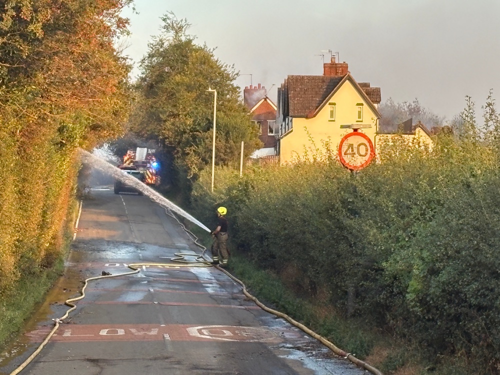 Fire crews working on Racecourse Lane, Stourbridge, near properties damaged by a major fire (PA)