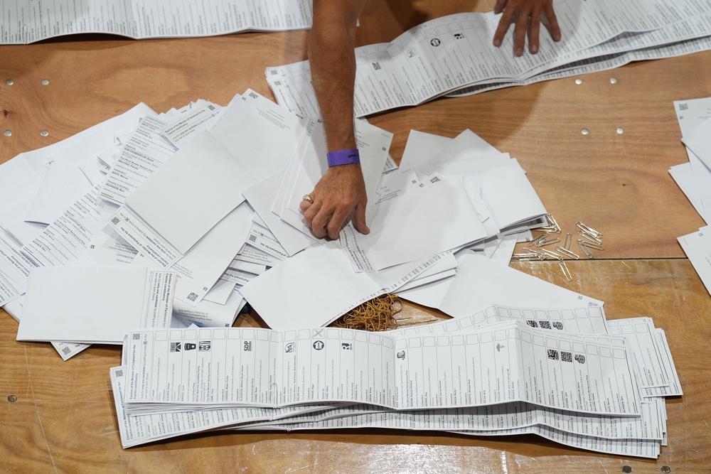 Ballot papers are sorted and verified for the Clacton by-election at Clacton Leisure Centre in Essex. The by-election was triggered by local MP and Reform UK leader Nigel Farage quitting in protest at the scrutiny of his finances from the press and the parliamentary authorities. Picture date: Thursday August 13, 2026. (PA Wire)