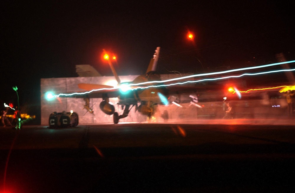 An F/A-18 Hornet launches from one of four steam driven catapults at night on the flight deck of USS Constellation 21 March 2003 (AFP/Getty)