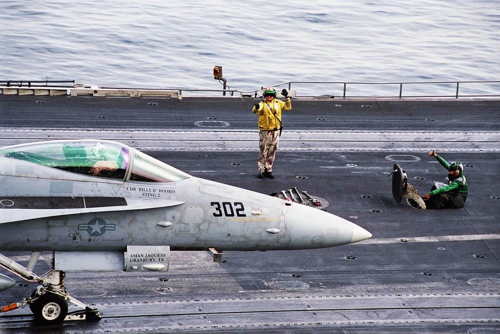 A flight director signals the pilot of a F/A-18C Hornet before take off from one of four steam powered catapults on the flight deck aboard USS Abraham Lincoln (CVN 72) April 1, 2003 in the Arabian Gulf (Getty)