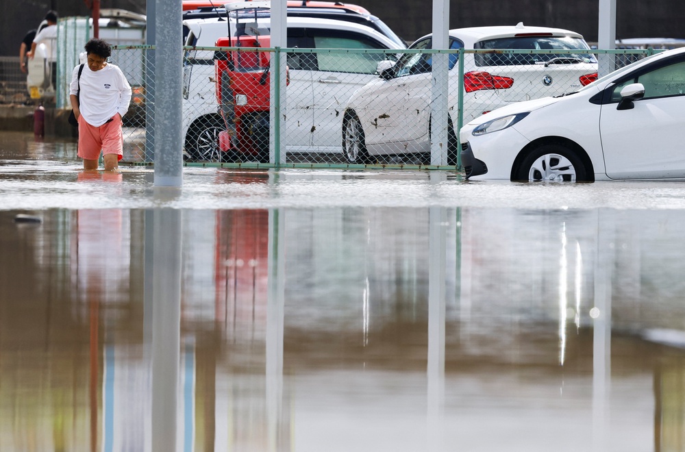 A resident walks in a flooded area after heavy rain in Oamishirasato, Chiba prefecture, Japan (Reuters)