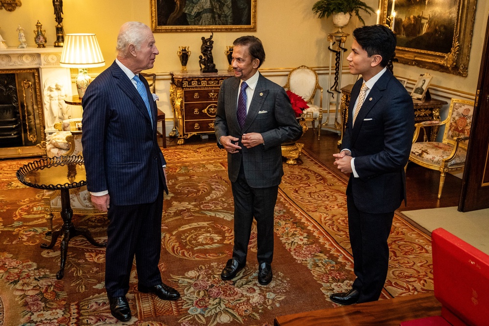 King Charles, left, meets with Brunei's Sultan Hassanal Bolkiah, centre, and Prince Mateen Darussalam at Buckingham Palace in London on 18 December 2024 (AFP/Getty)