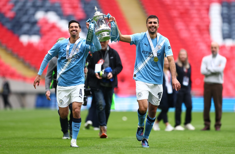 Reijnders and Rodri with the FA Cup in May. Neither midfielder looks like starting the new season at the Etihad (Getty)