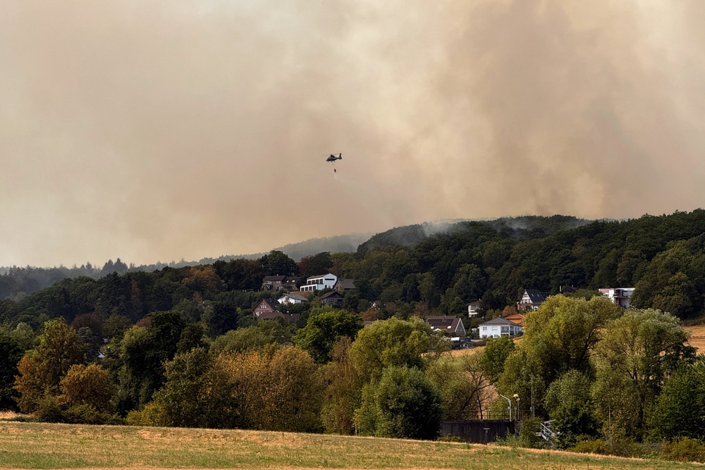 Smoke rises near a residential area where several hundred residents have been ordered to evacuate their houses following a wildfire in Huertgenwald-Gey, Germany (Reuters)