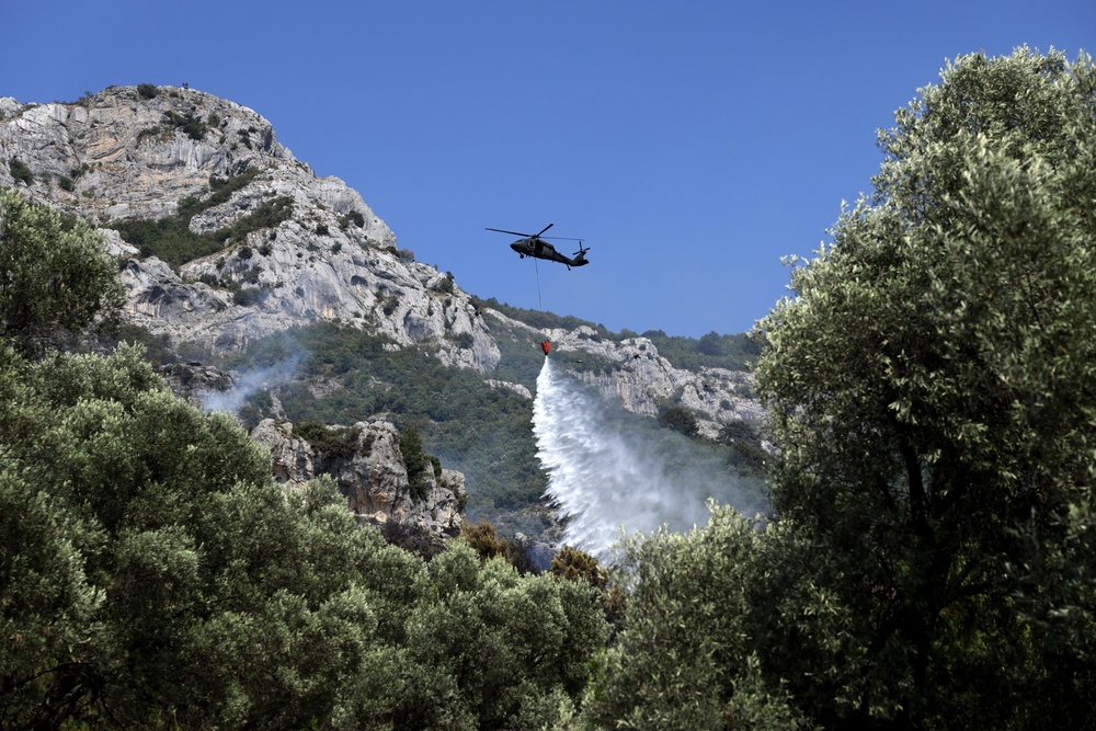 A firefighting helicopter drops water after a wildfire in Kruja, north of Tirana, Albania (AP)