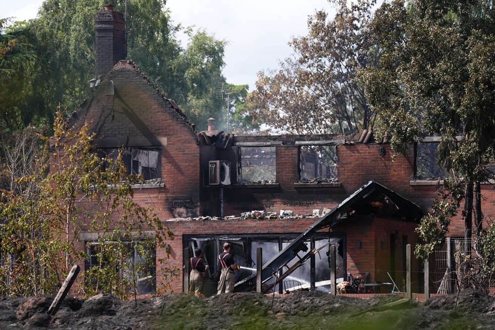 Firefighters looking at the burnt out remains of a house following a huge blaze in Stourbridge (Jacob King/PA) (PA Wire)