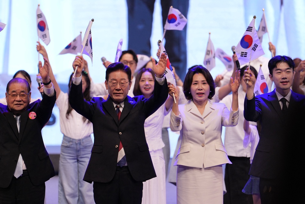 Lee Jae Myung and his wife Kim Hea Kyung wave the national flag (AFP/Getty)