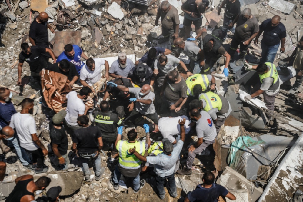 First aid responders and residents gather as they search the site of an Israeli airstrike that targeted a neighbourhood in the southern Lebanese village of Deir al-Zahrani (AFP/Getty)
