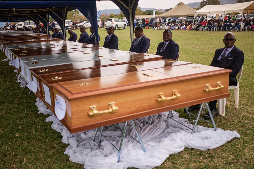 Funeral pallbearers sit behind caskets during a memorial service for the victims (AP Photo/Mkhululi Thobela)