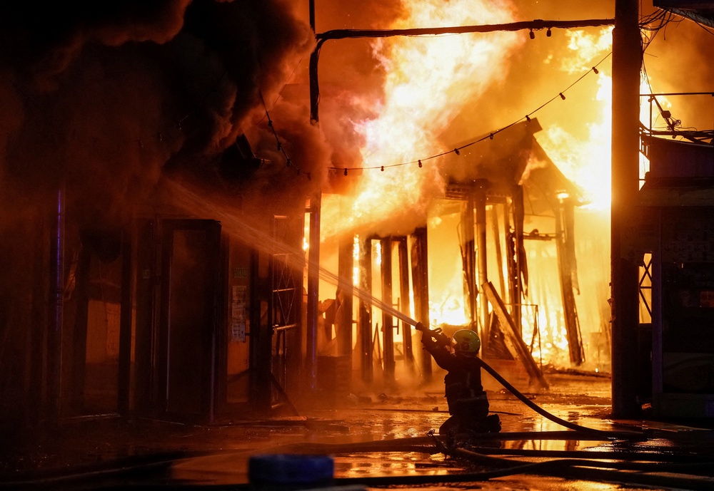 A firefighter works at a site of a book market hit by a Russian missile strike (Reuters)