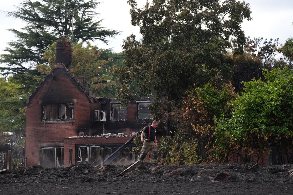 A firefighter outside the burnt-out remains of a house in Stourbridge in the West Midlands (Jacob King/PA) (PA Wire)