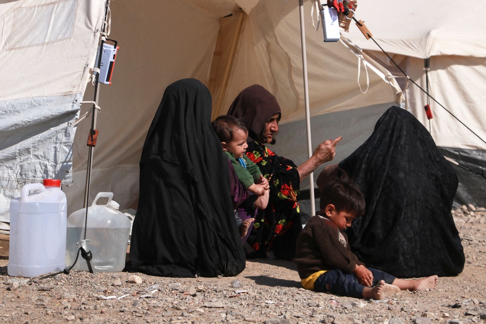Afghan women and children sit outside their makeshift shelters at a camp set-up after earthquake on the outskirts of Herat (AFP/Getty)