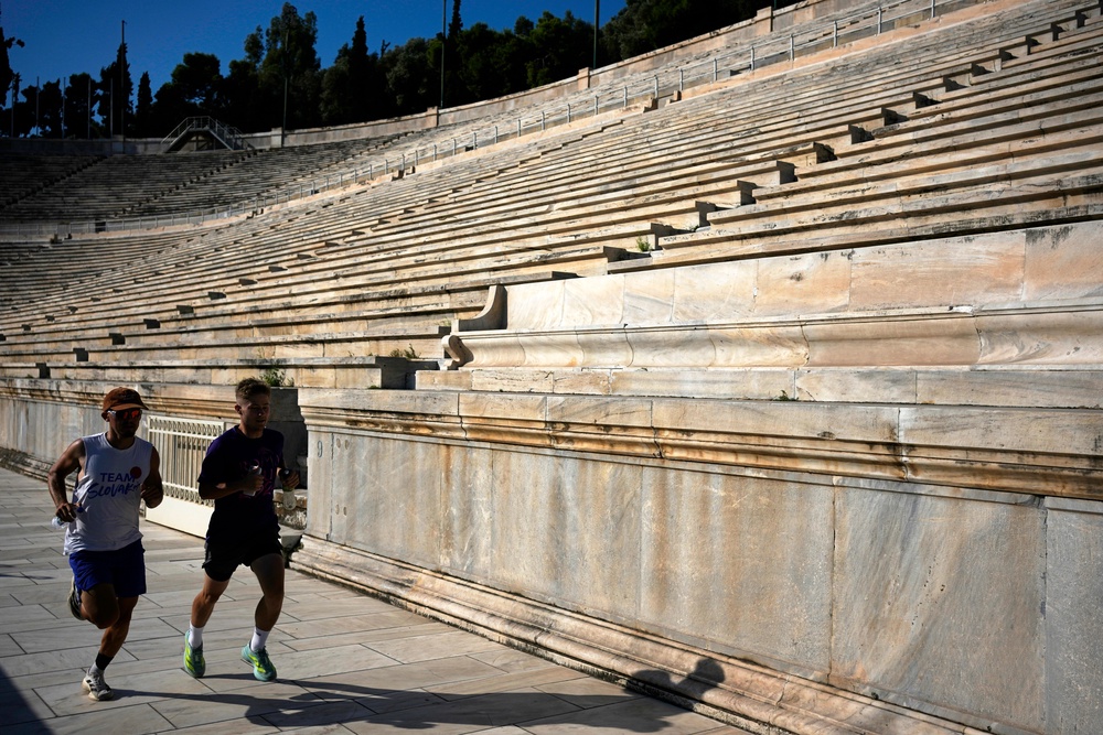 Two men run at the Panathenaic Stadium during the renovation works (AP)