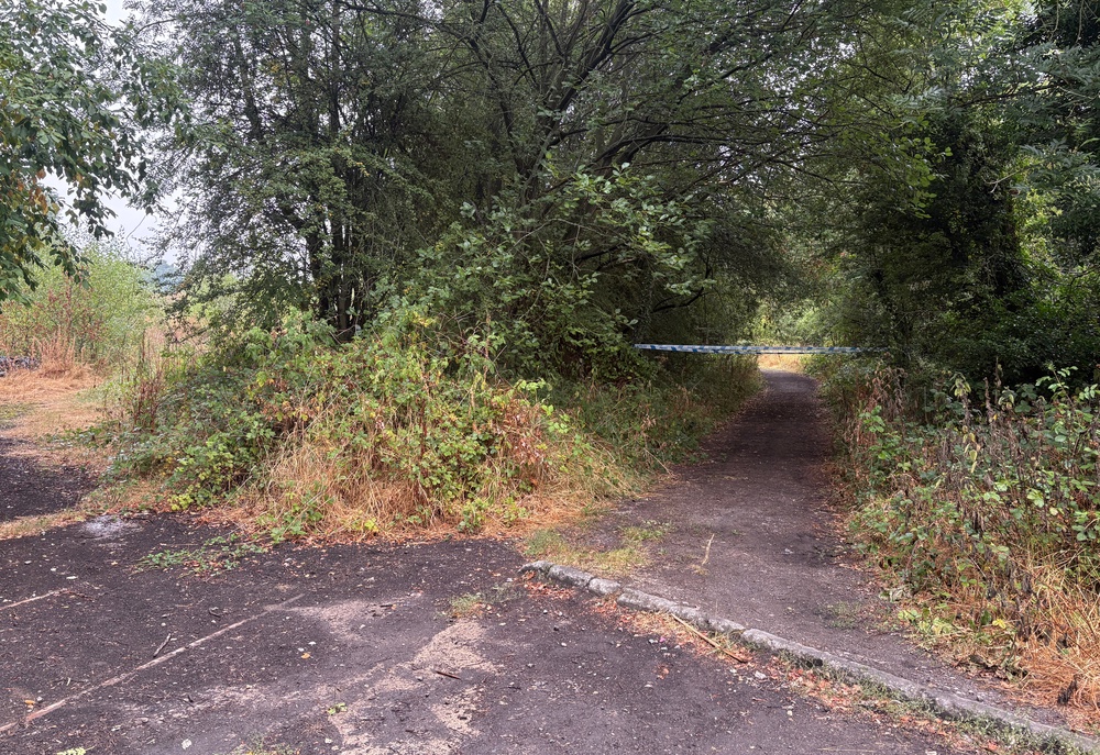 Police tape blocks the entrance at the old train line footpath off Blacker Lane (PA)