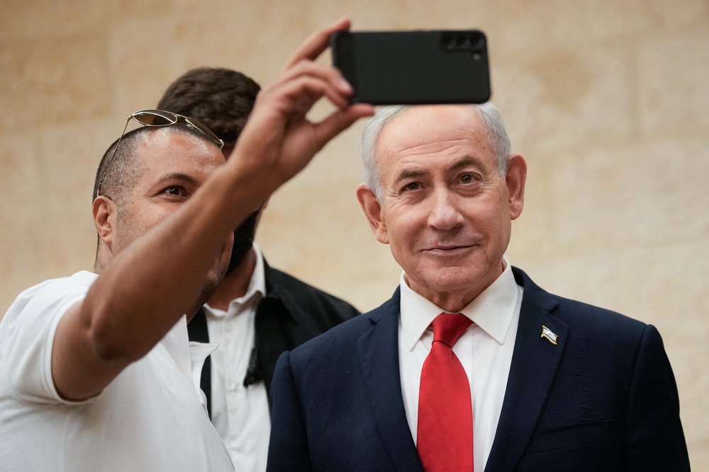 Israeli Prime Minister Benjamin Netanyahu, takes a selfie with a supporter as he arrives to cast his ballot at his party Likud's main polling station during primary elections ahead of Israel's general election in October in Jerusalem on August 17, 2026. (AFP/Getty)