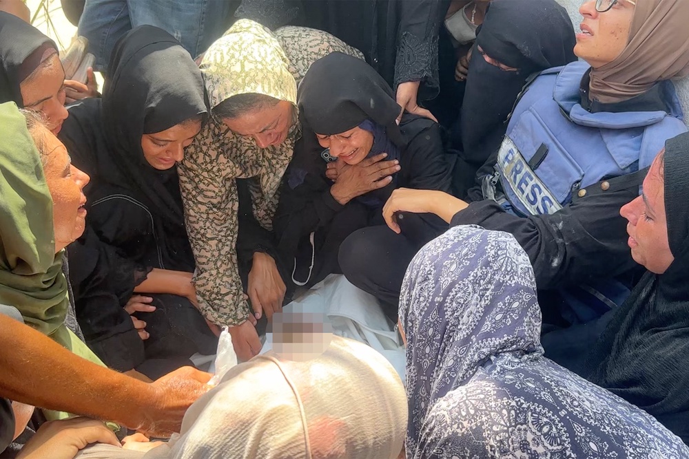 Mourners, including Baraa on the left, collapse around Mariam (Supplied)