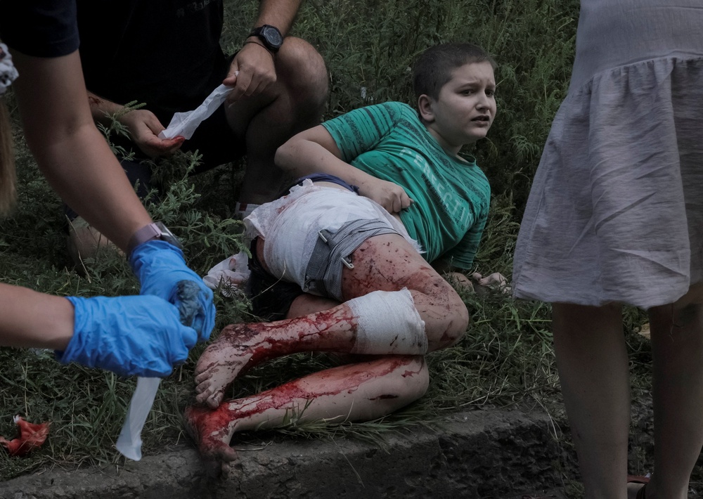 Volunteers treat a wounded boy at the site of an apartment building hit by a Russian strike in Donetsk (Reuters)