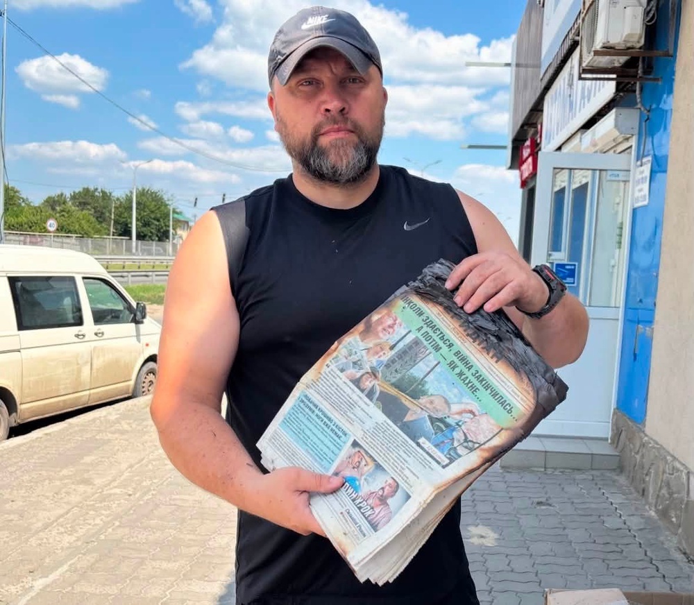 Yevhen Khrypun, chief editor of Mezhivskyi Meridian, holding copies of the newspaper damaged by a Russian attack in Mezhova, Dnipropetrovsk region, August 2026 (Yevhen Khrypun / Supplied)