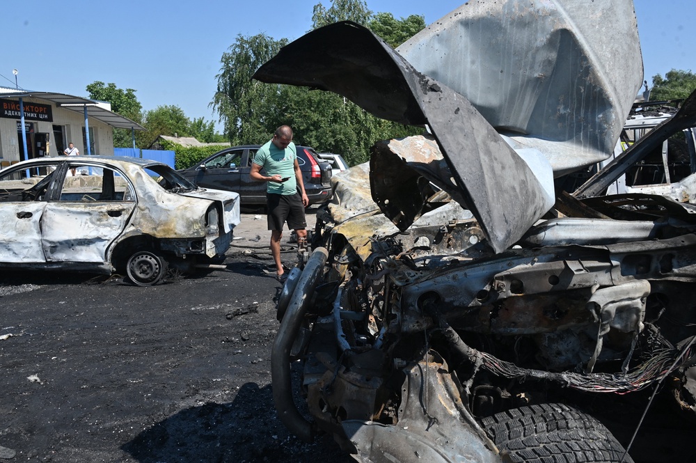 A man inspects burnt-out cars at the site of an air attack in Kharkiv (AFP/Getty)