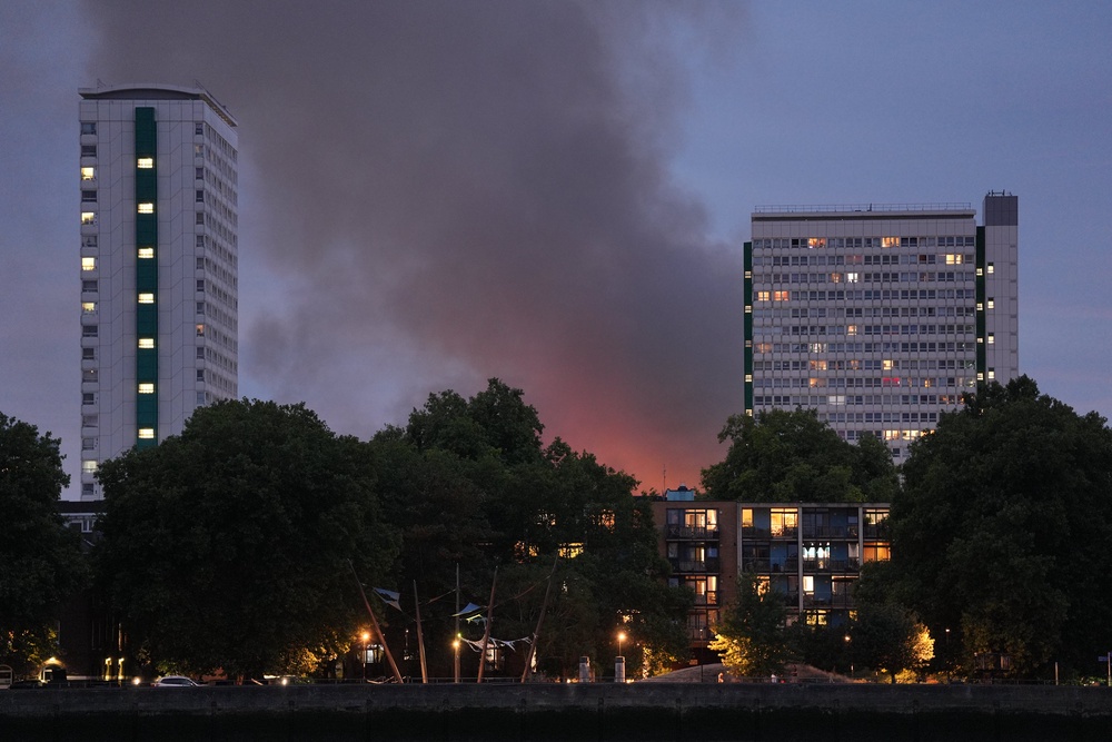 Smoke and flames from the blaze in Deptford, as seen from Millwall (PA)