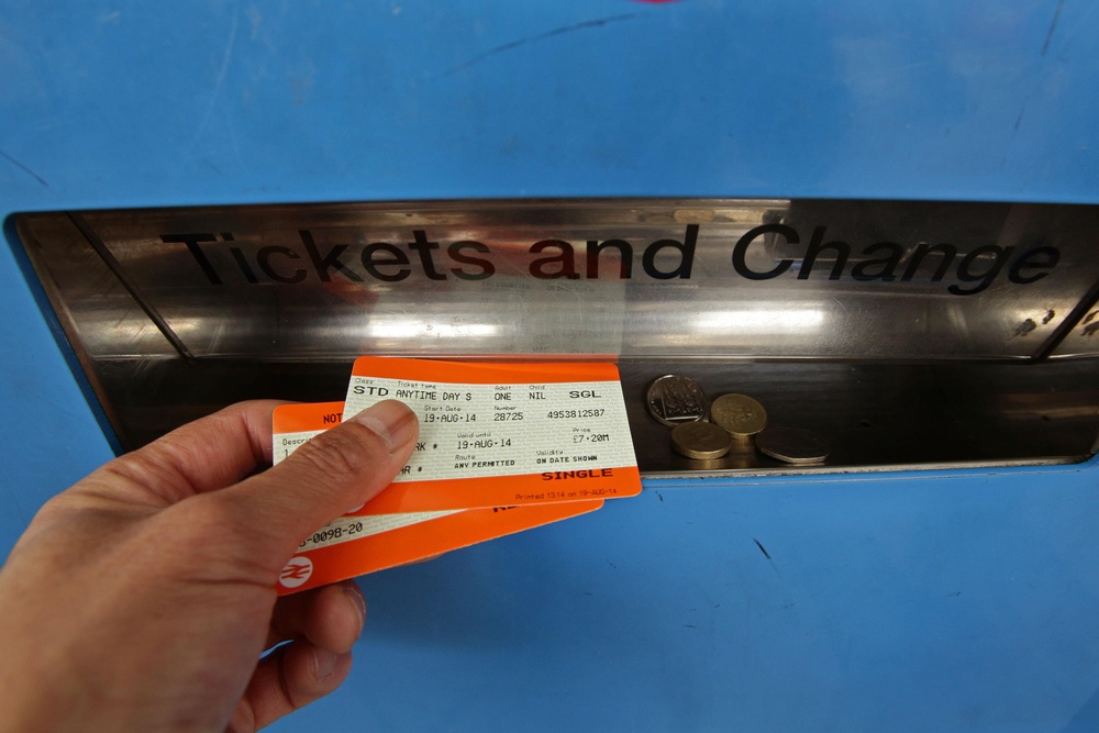 A passenger collecting train tickets from a machine at Finsbury Park station in north London (PA Archive)