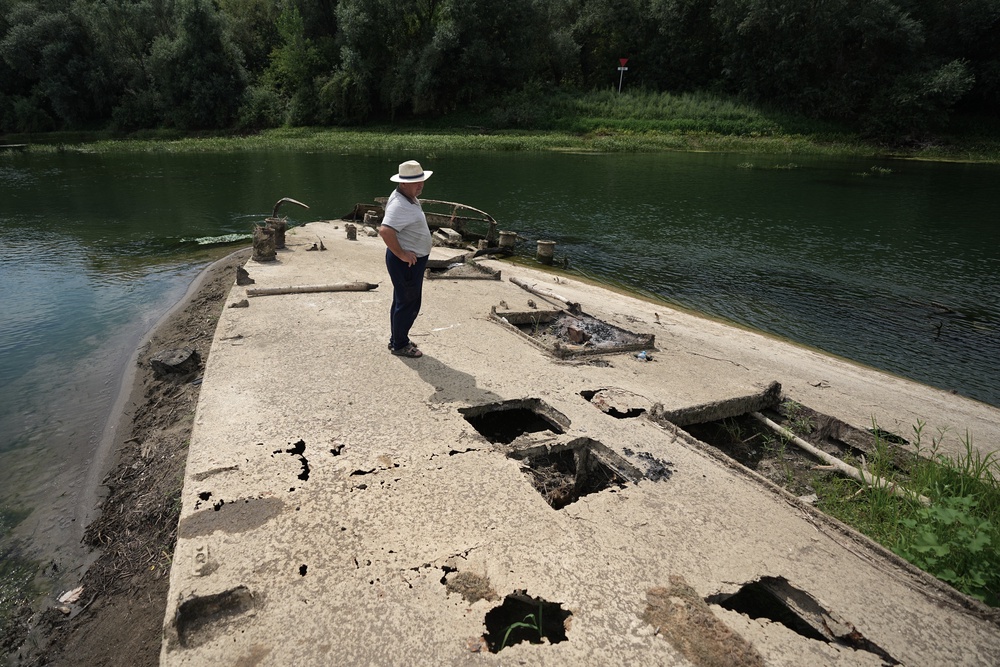 Stanislav Kozenko stands on the wreckage of the old steam boat (AP)