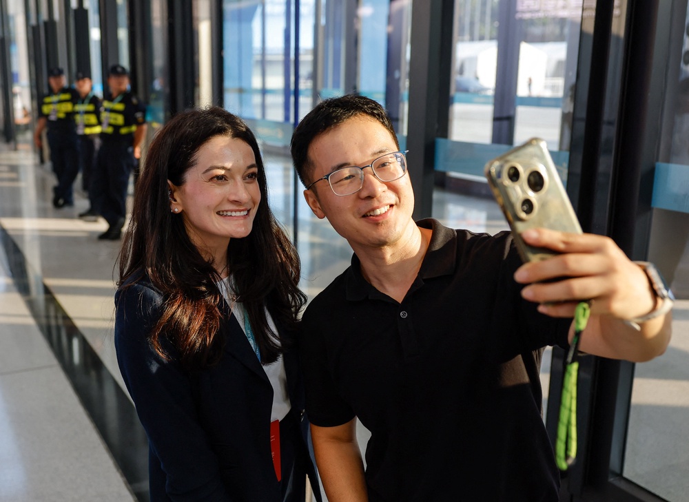 Madison Huang, Senior Director of Product Marketing at NVIDIA and daughter of Jensen Huang, poses for a selfie with a visitor, at the 2026 World Robot Conference, in Beijing (Reuters)