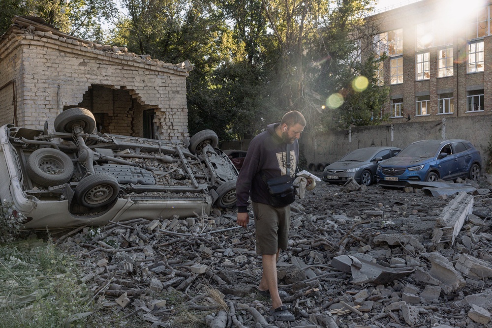 Residents walk through debris in a courtyard following a Russian missile strike on Thursday (Getty)