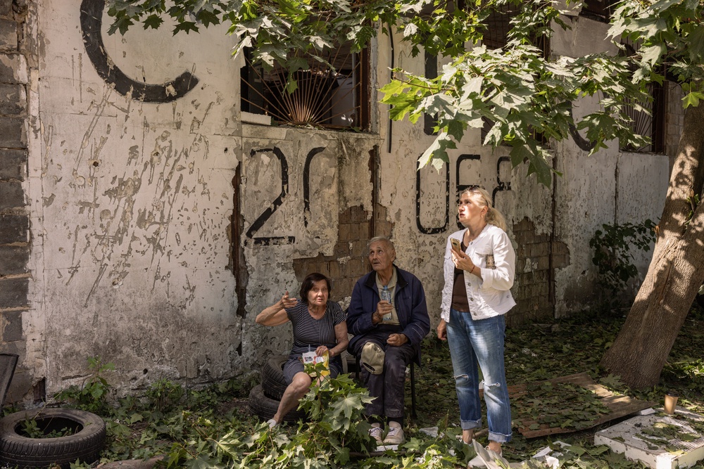Locals gather outside a damaged apartment building in Kyiv (Getty)