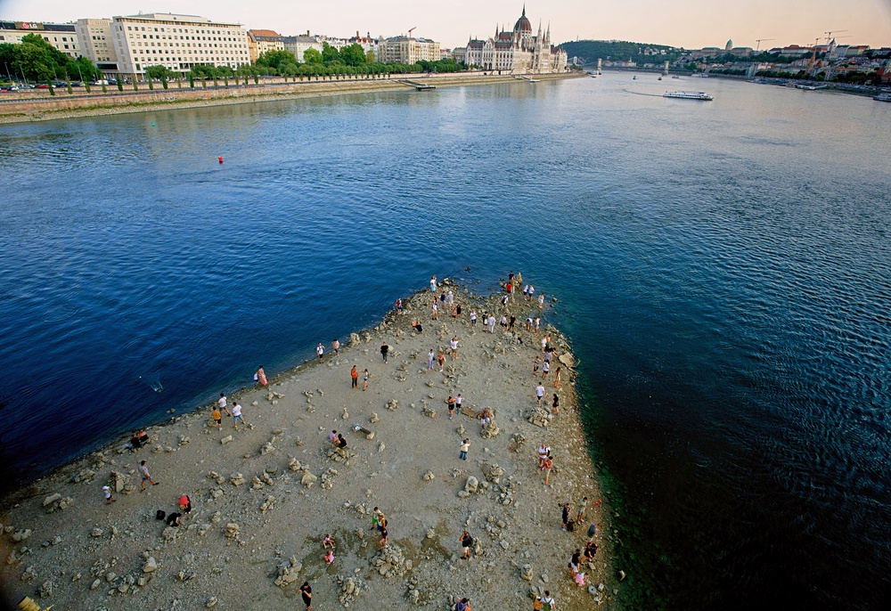 People walk on a sandbar underneath the Danube's Margareth Bridge in downtown Budapest, Hungary, on Aug. 5, 2026, as the river, which runs through 10 European countries, has receded never-before-seen low water levels. (AP Photo/Bela Szandelszky, File) (Copyright 2026 The Associated Press. All rights reserved)