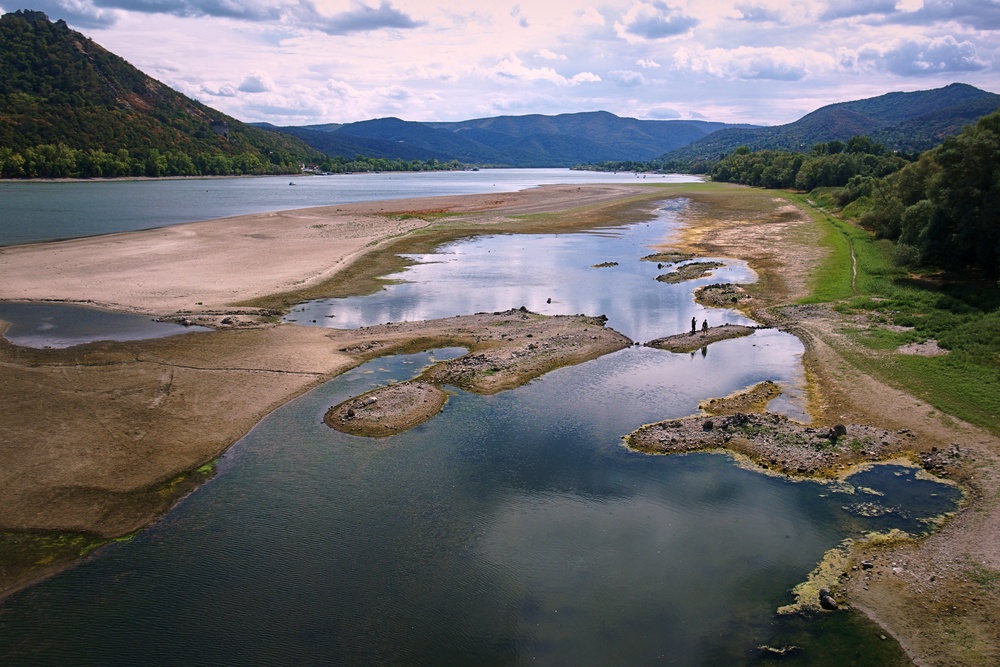 People walk on sandbanks exposed by record-low water levels in the Danube River after drought and extreme heat near Nagymaros, Hungary, on Aug. 18, 2026. (AP Photo/Bela Szandelszky) (Copyright 2026 The Associated Press. All rights reserved.)