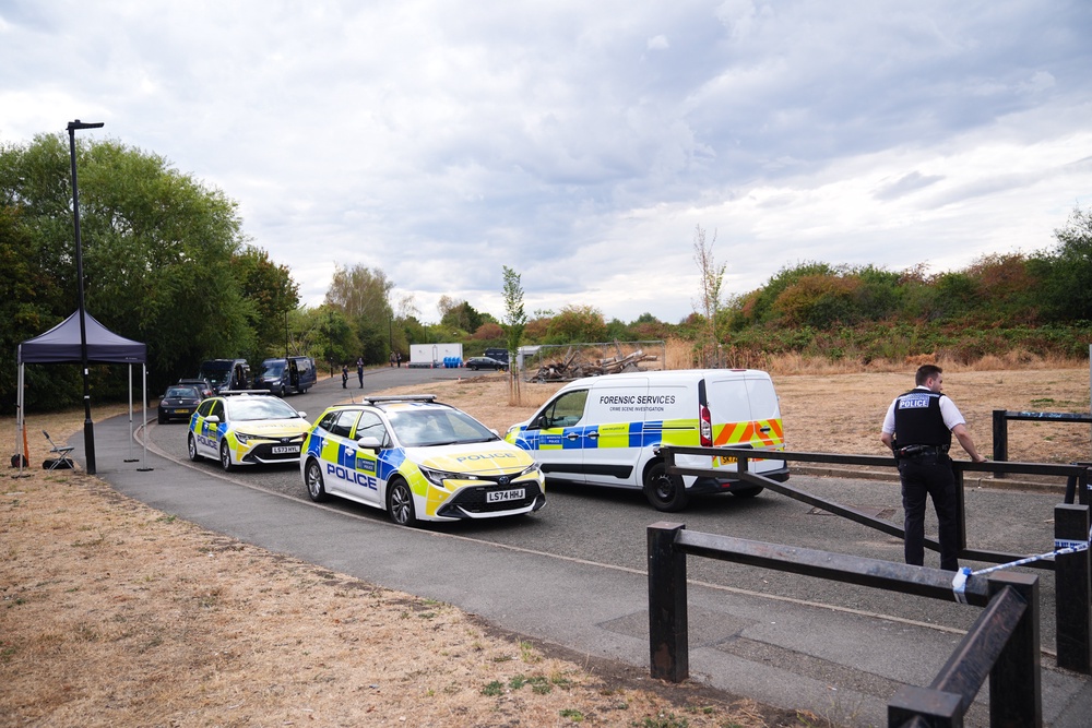 Police activity near to the scene, where a member of the public found human remains in woodland in Feltham, south-west London (PA)