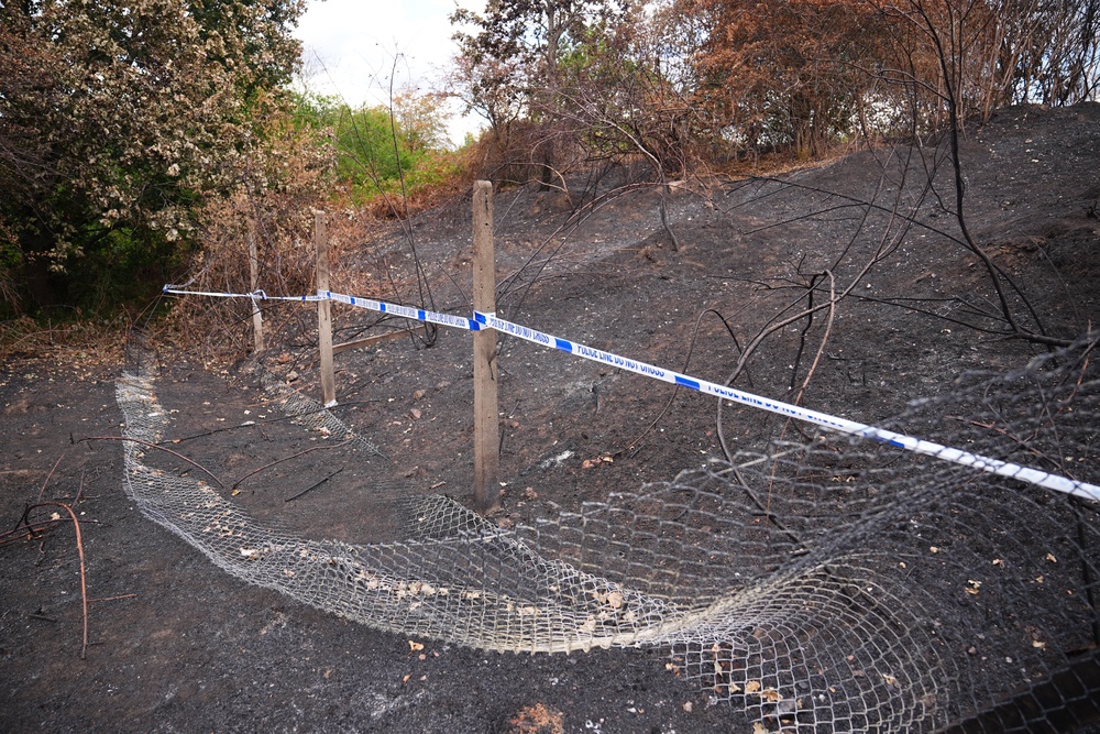 Police tape near to the scene, where a member of the public found human remains in woodland in Feltham, southwest London (PA)