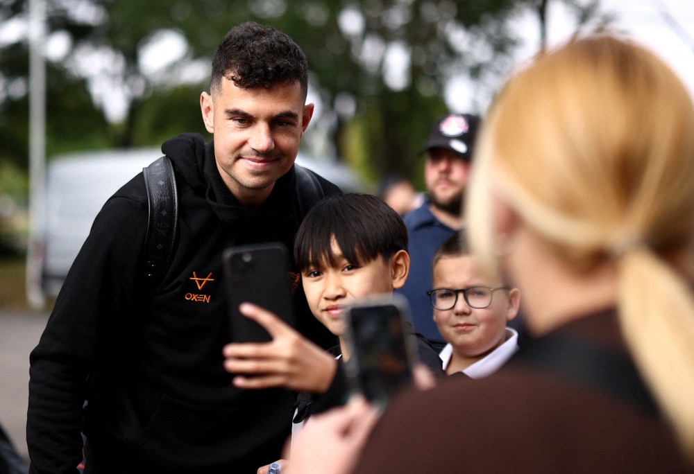 Hull City's John Egan takes selfies with fans as he arrives (Reuters)