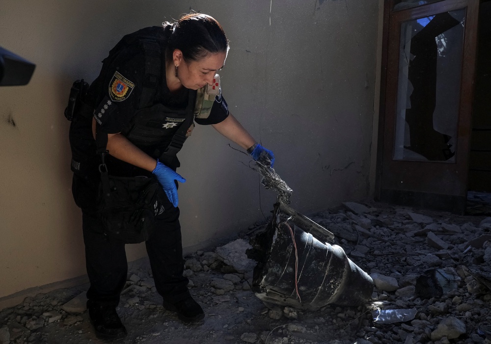 A police officer inspects a part of a Russian drone at a training base of the FC Chornomorets Odesa damaged during a Russian drone strike (Reuters)
