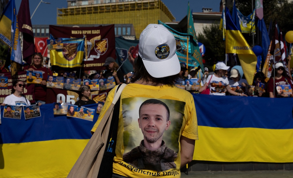 A Ukrainian woman wearing a T-shirt with a printed picture of a missing Ukrainian soldier on the back (Reuters)