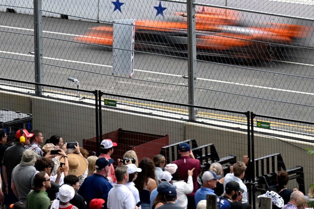 An IndyCar streaks by spectators during a series qualifying run (AP)