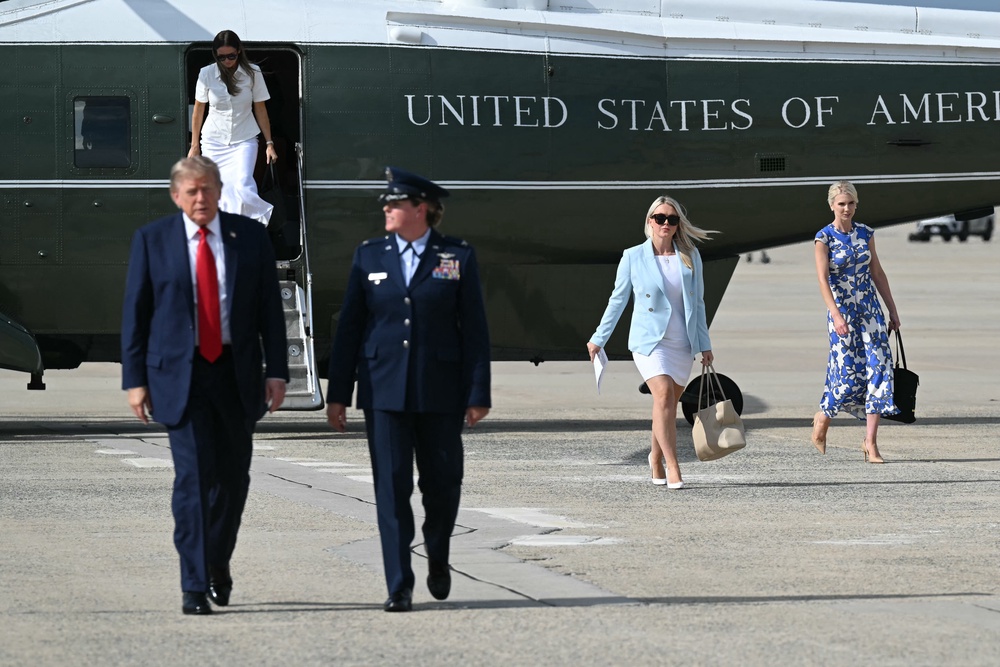 Natalie Harp and White House press secretary Karoline Leavitt trail the president at Joint Base Andrews as he heads to a campaign rally in South Carolina Friday (AFP/Getty)
