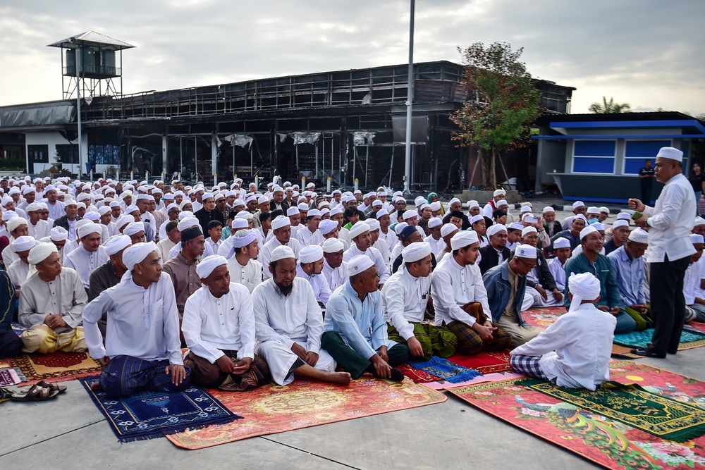 File: Members of the Thai Muslim community take part in prayers next to a damaged petrol station days after a bomb attack in Thailand's southern province of Narathiwat in Jan 2026 (AFP/Getty)