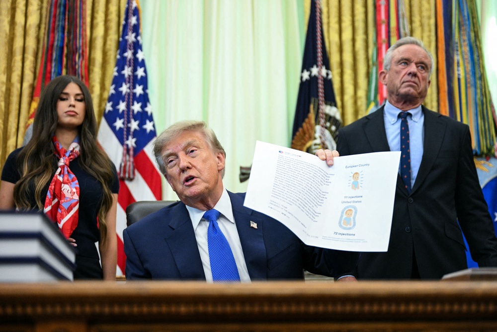 Health Sec. Robert F. Kennedy, Jr., right, looks on as President Donald Trump speaks at a signing of an executive order calling for more research and flexibility on vaccines at the White House earlier this month. Kennedy has also questioned the ties between vaccines and autism (AFP via Getty Images)