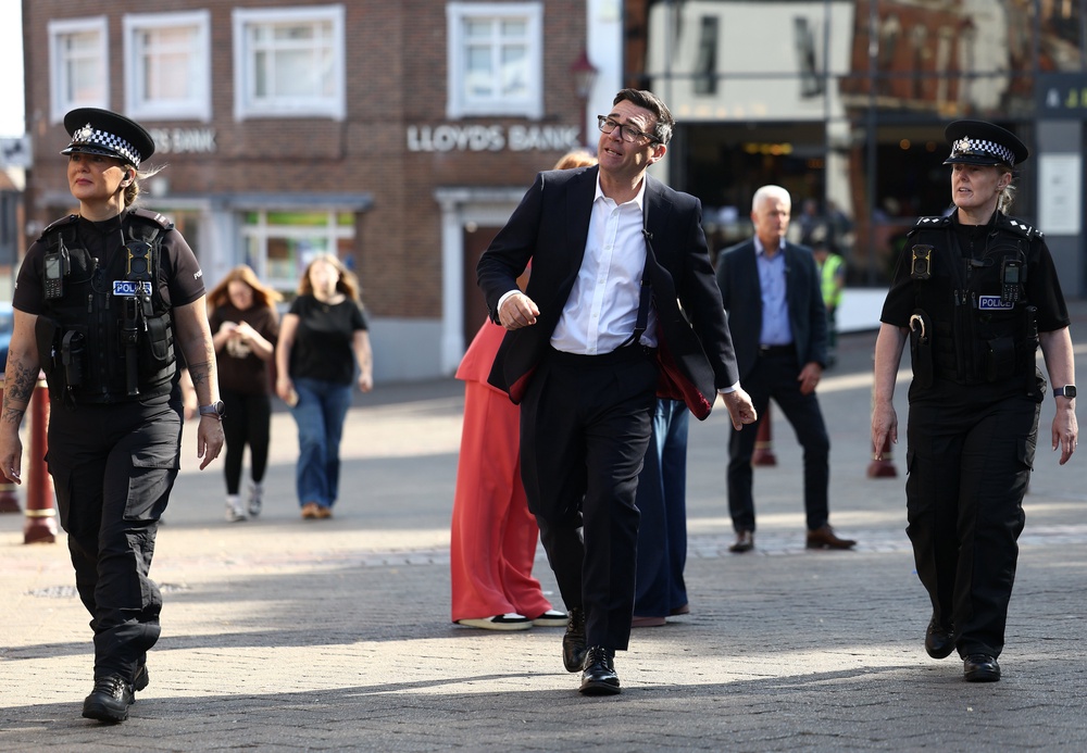 Prime Minister Andy Burnham seen with police officers as they walk past shops on August 11, 2026 in Ilkeston, England (Getty)