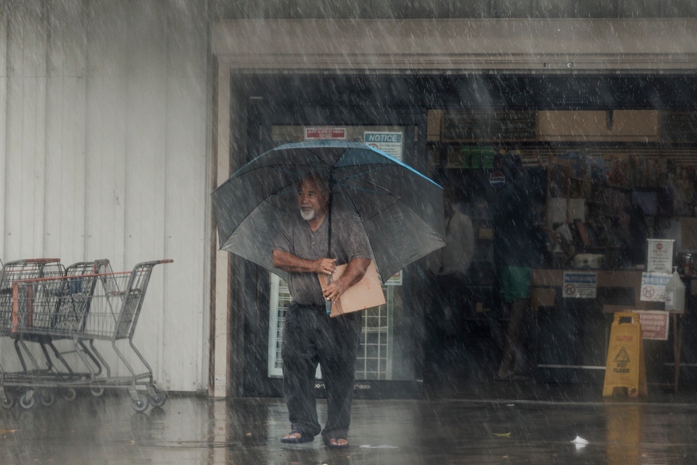 A resident carries supplies during Hurricane Lala in Hawaiian Ocean View, Hawaii, on Saturday, Aug. 15, 2026. The storm side-swiped the Big Island but still brought deadly flooding (AP)