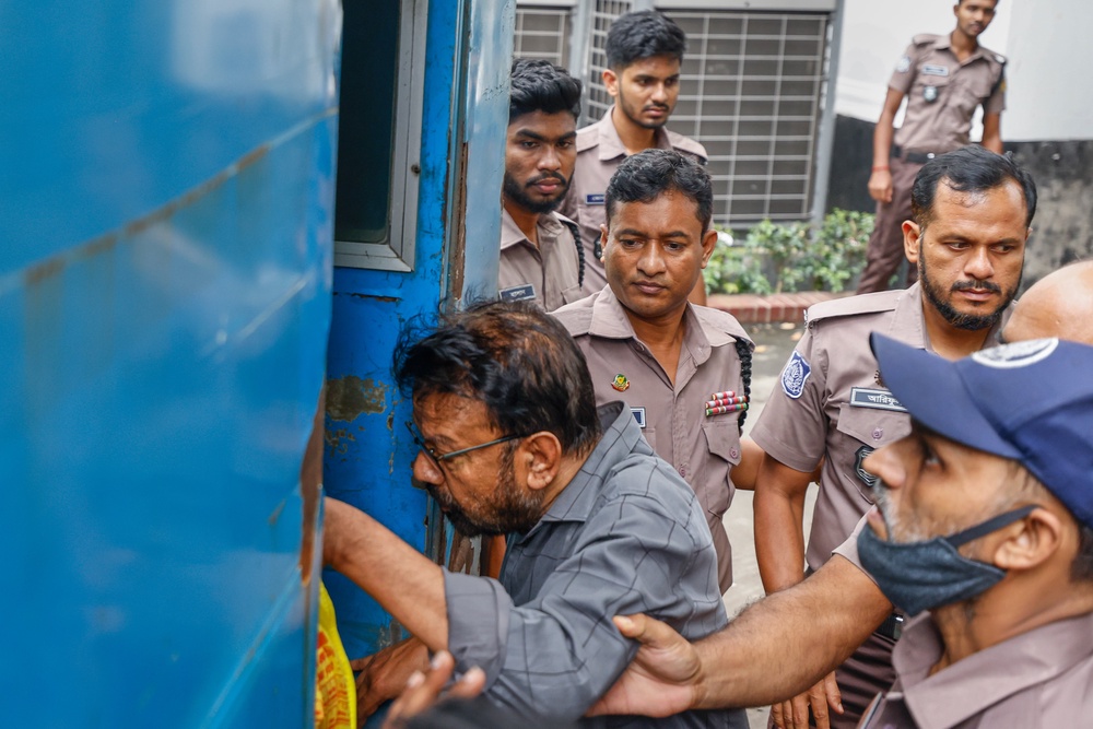 Shyamal Dutta, editor of daily Bhorer Kagoj is escorted into a prison van after the International Crimes Tribunal ordered him to remain jailed, in Dhaka, Bangladesh, Monday, 24 Aug 2026 (AP)