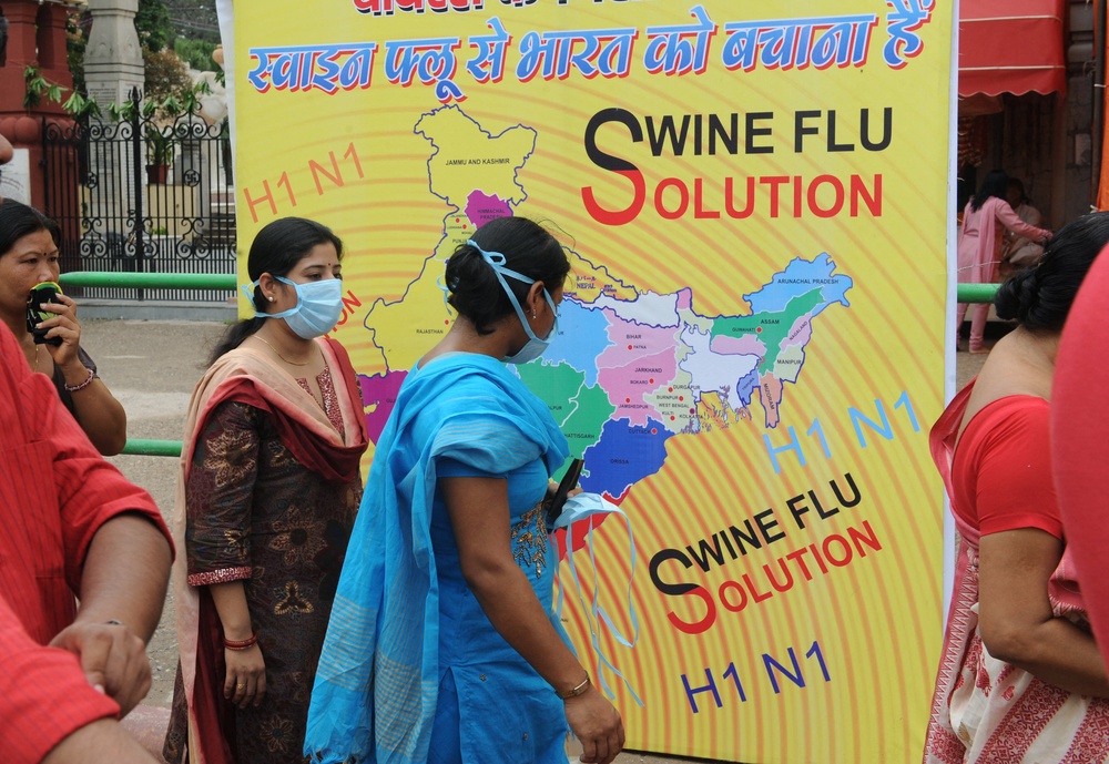 Indian women wear masks to prevent swine flu infection as they queue up at a temple to pray during the 'Janmashtami' festival in Delhi on 14 August 2009 (AFP/Getty)