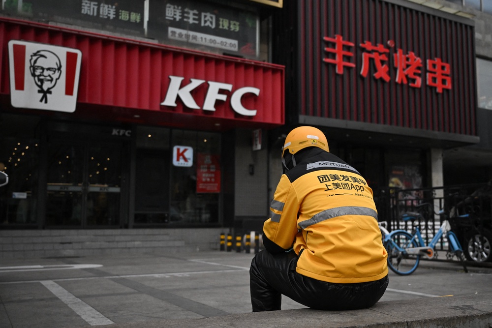 A food delivery person for Meituan waits for orders outside a KFC outlet in Beijing (AFP/Getty)